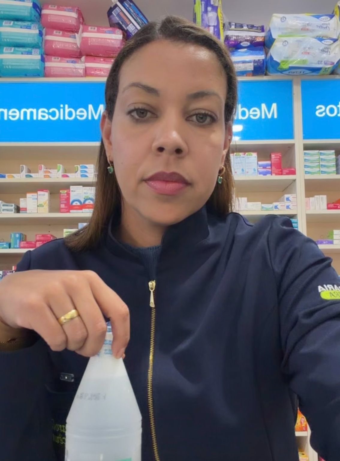 Ana Carolina de uniforme apresentando um produto na farmácia